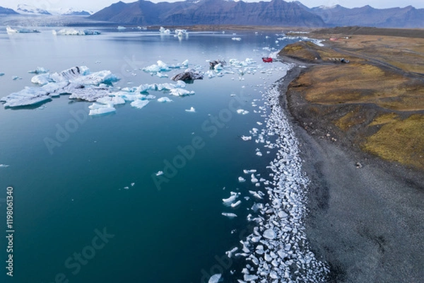 Fototapeta Breathtaking aerial view of Jokulsarlon Glacier Lagoon at sunset, icebergs floating in the serene waters of Iceland most popular tourist destination.
