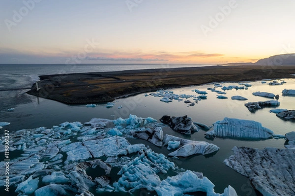 Fototapeta Breathtaking aerial view of Jokulsarlon Glacier Lagoon at sunset, icebergs floating in the serene waters of Iceland most popular tourist destination.
