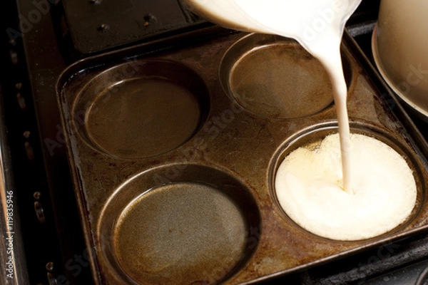 Fototapeta Pouring Yorkshire pudding batter into a pan