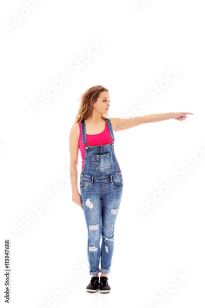 Obraz Young happy woman pointing at something