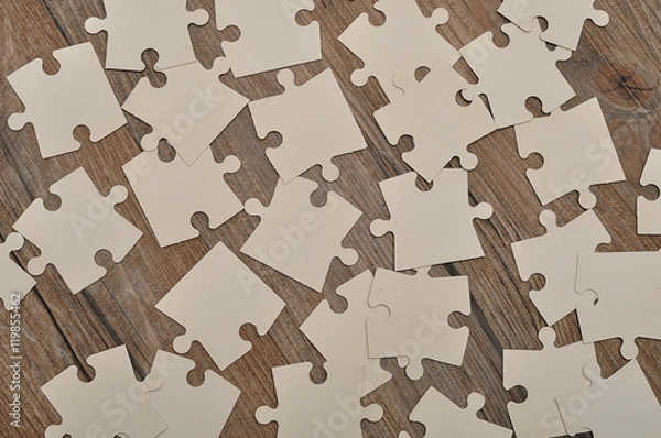 Obraz White puzzle pieces on a wooden background