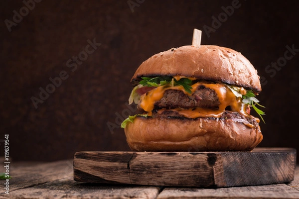 Obraz Tasty grilled burger with lettuce and mayonnaise ,on a rustic wooden table