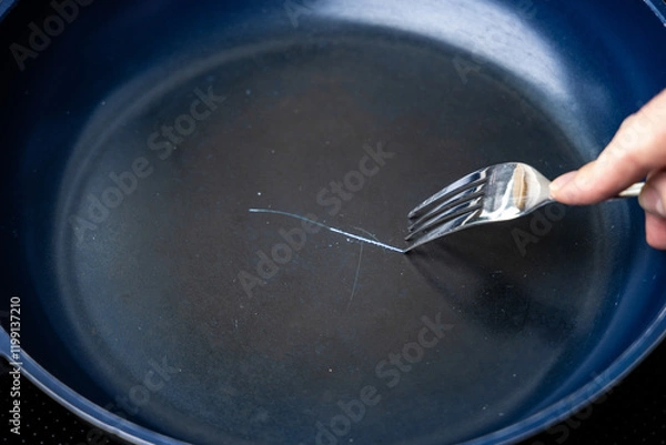 Fototapeta Fork scratching the non stick coating on a frying pan