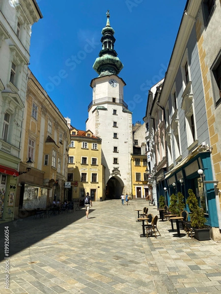 Fototapeta Historic street in Bratislava with St. Michael's Gate under a clear blue sky