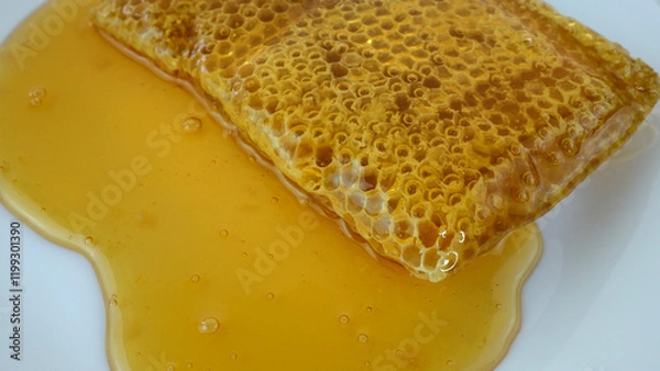 Obraz honey flowing over natural honeycomb