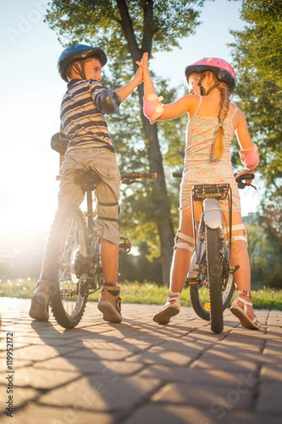 Obraz happy  girl and boy riding bike in park