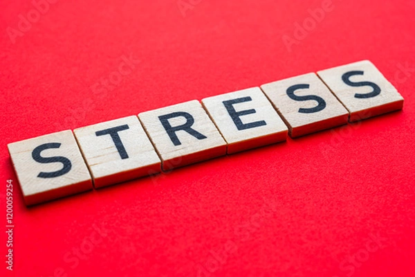 Fototapeta Word Stress, composed with wooden alphabet blocks, on red surface.