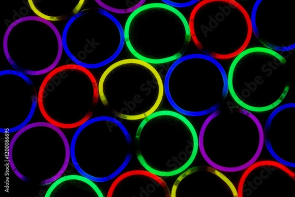 Fototapeta Neon glow sticks arranged in circles shinning in the dark