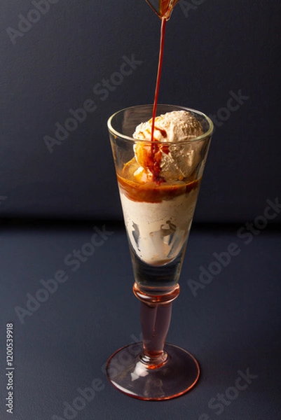 Fototapeta serving an affogato coffee in a tall glass cup on a dark blue background