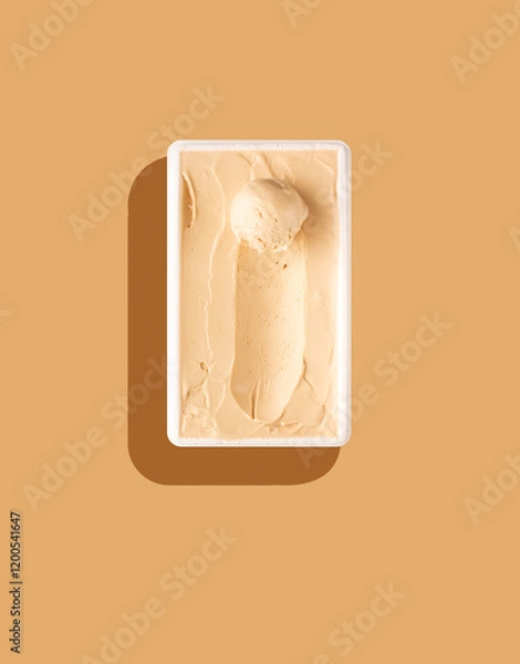 Fototapeta scoop of vanilla ice cream on a bed of ice cream on white bowl, flat lay, brown background