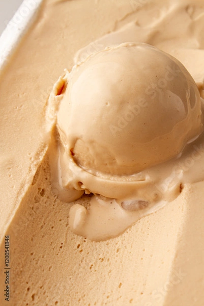 Fototapeta scoop of creamy vanilla ice cream on a bed of ice cream