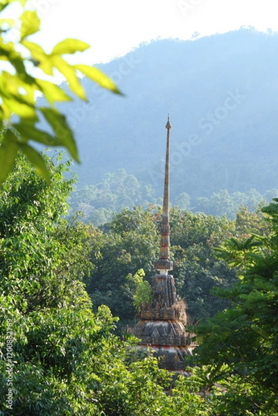 Fototapeta Thai temple located in the middle of the forest. behind the mountain