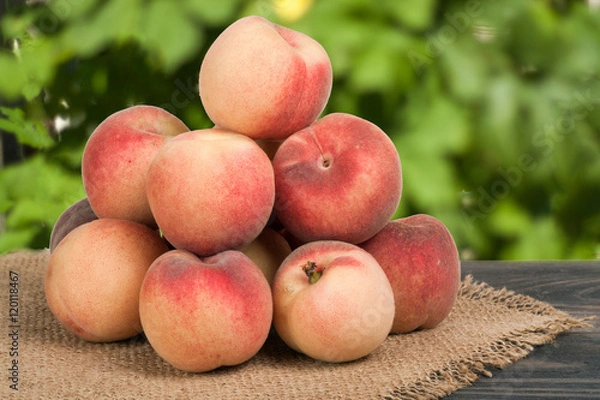 Fototapeta heap of peaches on a wooden table with  blurred background