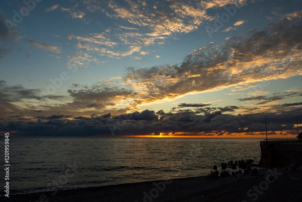 Fototapeta Red sunset over the sea, rich in dark clouds, rays of light. Black Sea coast, early autumn