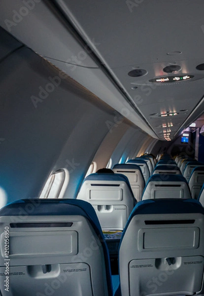 Fototapeta Inside a nearly empty aircraft cabin on a tranquil flight in early morning light