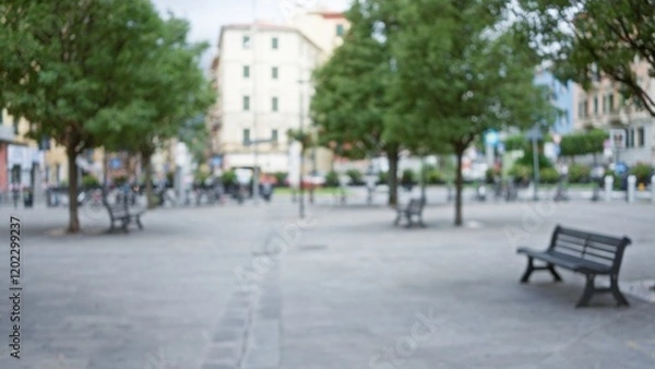 Fototapeta Blurry scene of la spezia street with benches, trees, and buildings in europe providing a serene urban setting.