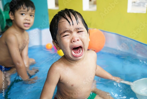 Fototapeta Little boy crying bitterly in the pool