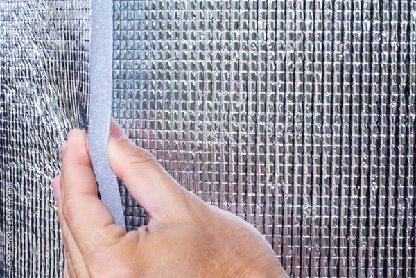 Obraz Heat insulating aluminum sheet. Insulates from outside heat and retains coolness. Silver rolls material building materials in a hardware store. close-up, foil film.