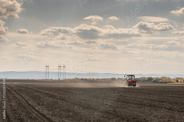 Fototapeta Tractor spreading artificial fertilizers