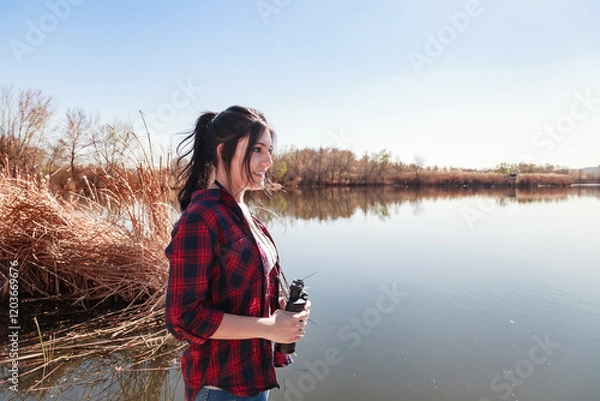 Obraz Reflection of sky and trees in calm water near a young woman