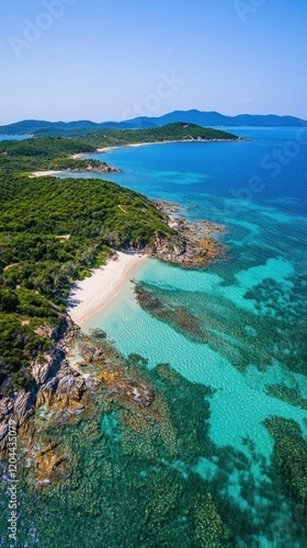 Fototapeta Aerial view of a serene beach with clear turquoise waters and lush green coastline.
