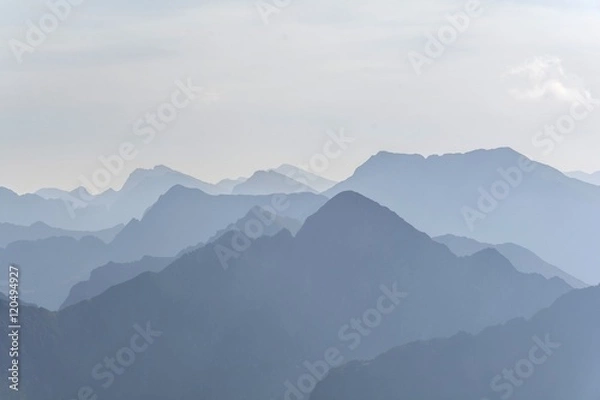 Fototapeta Silhouette of blue mountains in the fog. View of Moldoveanu peak, the highest peak from Romanian Carpathian Mountains range. Seamless background.