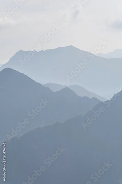 Obraz Silhouette of blue mountains in the fog. View of Moldoveanu peak, the highest peak from Romanian Carpathian Mountains range. Seamless background.