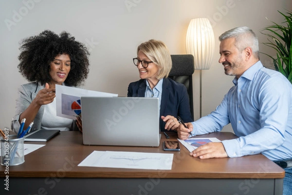 Fototapeta Casual meeting of smiling diverse business team analyzing financial data