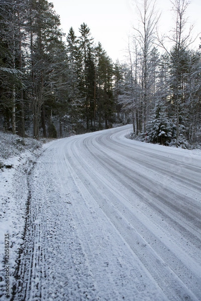Fototapeta Slippery winter road on a cloudy winter day. Image taken after first snow has arrived in Finland.