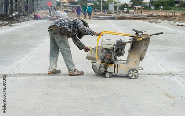 Fototapeta Labor construction worker using machine cutter joint concrete floor slab