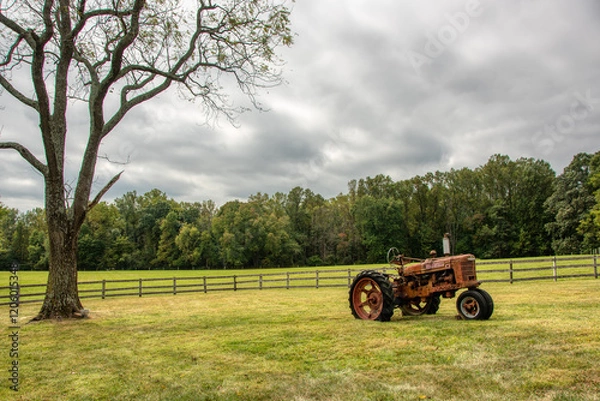 Obraz Old rusty tractor in a field.