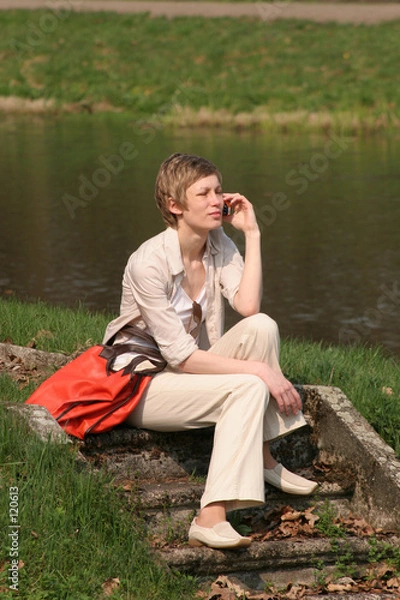 Fototapeta calling white woman is sitting on the stairs