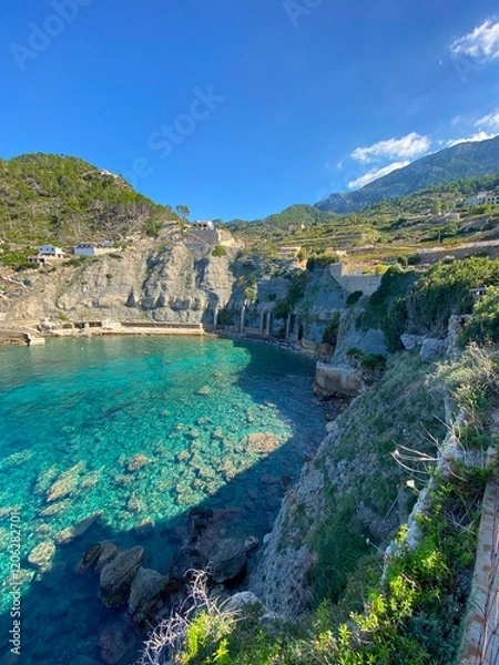 Fototapeta A bay on the island of Mallorca, with cliffs, mountains, and a blue sky.