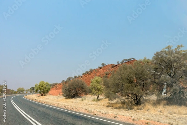 Fototapeta Bend in the road near Stuarts Well in the Northern Territory of Australia, showing dry outback landcape and flora.