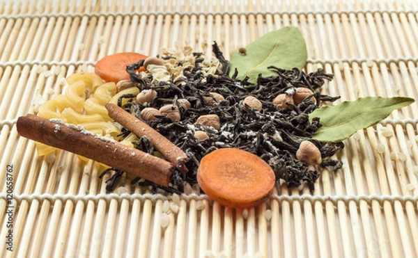 Obraz Dried tea, pasta, carrot and spices on wood background, front view