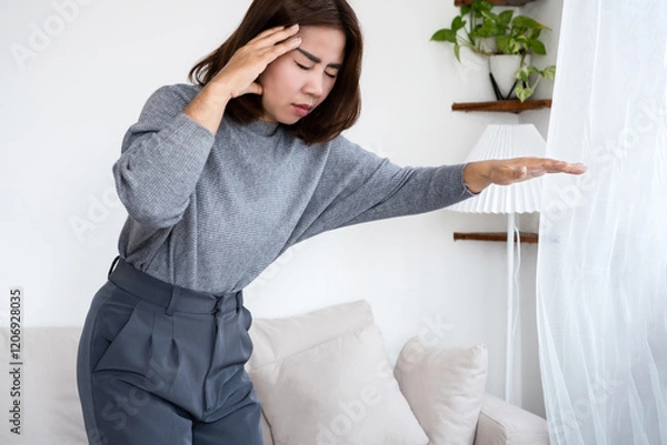 Obraz Asian woman experiencing dizziness and lightheadedness upon standing due to postural hypotension