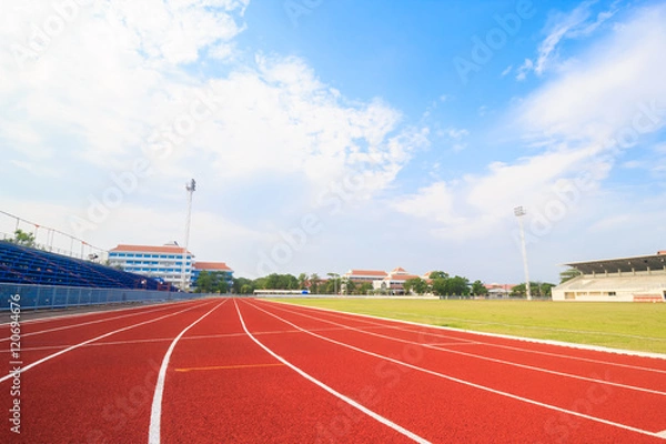 Fototapeta Running track ,Green lawn and blue sky.