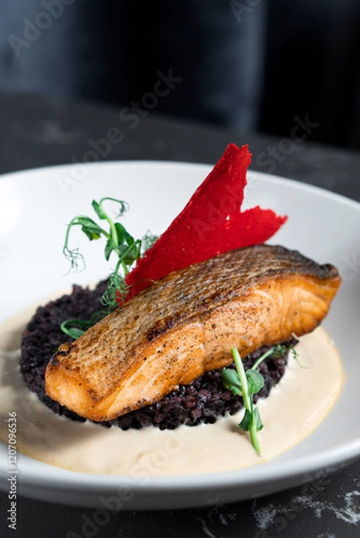 Fototapeta A piece of baked red fish on vegetables in a white bowl