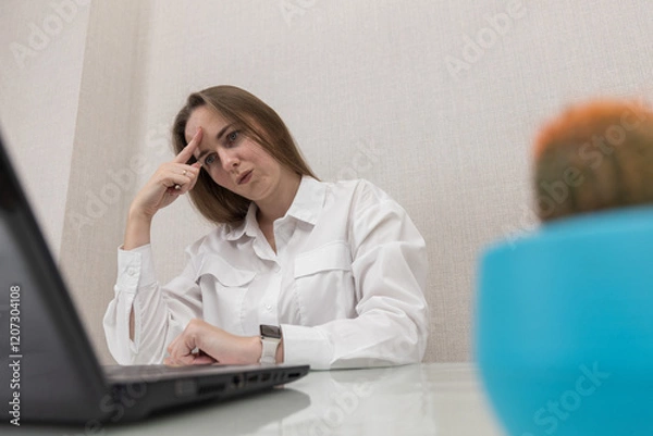 Fototapeta Female person office worker or freelancer works in office or at home at a computer. Business woman concentration look in laptop screen, she's not doing very well at work. People thought while working.
