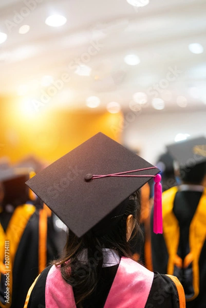 Fototapeta A rear view of graduates seated in rows during a graduation ceremony