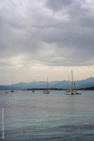 Fototapeta Sailing boats in the coast of Sardinia on a cloudy day in Italy