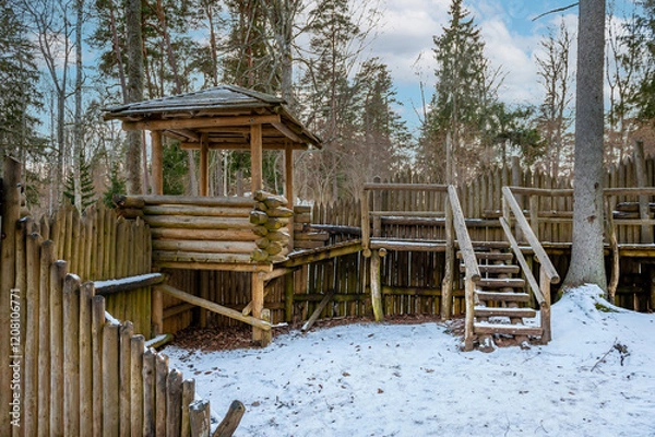 Obraz Wooden fortress wall against the forest. Wooden installation in the style of an ancient city. Stockade fence made of logs. Kartavkalna Nature Trail, Latvia.