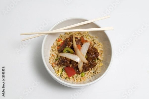 Obraz Bowl of fried rice topped with chicken and vegetables