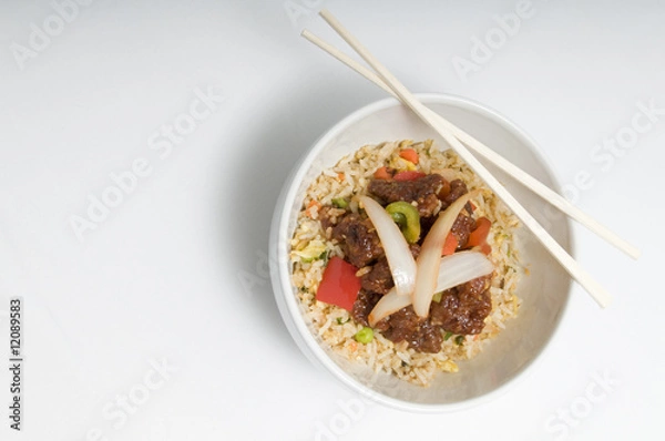 Obraz Bowl of fried rice topped with chicken and vegetables