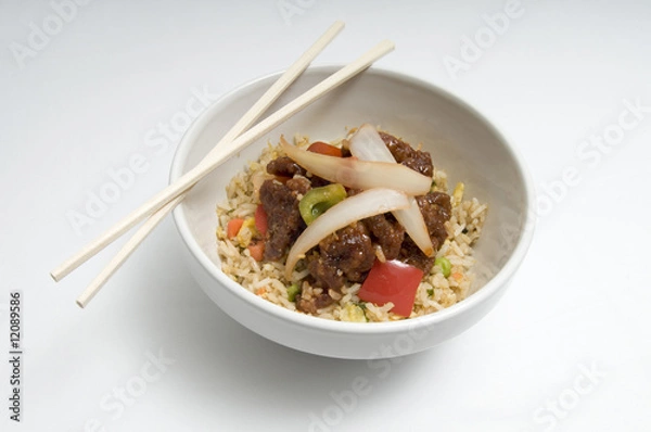 Obraz Bowl of fried rice topped with chicken and vegetables