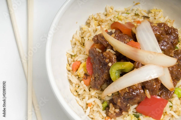 Obraz Bowl of fried rice topped with chicken and vegetables