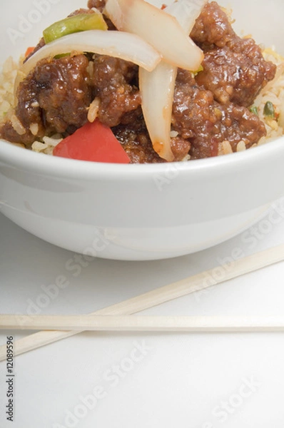 Obraz Bowl of fried rice topped with chicken and vegetables