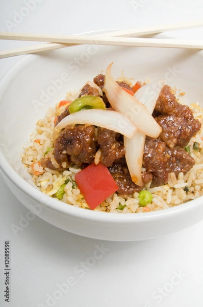 Obraz Bowl of fried rice topped with chicken and vegetables