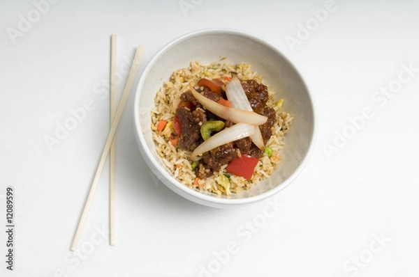 Obraz Bowl of fried rice topped with chicken and vegetables