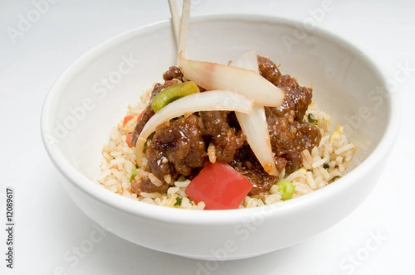 Obraz Bowl of fried rice topped with chicken and vegetables